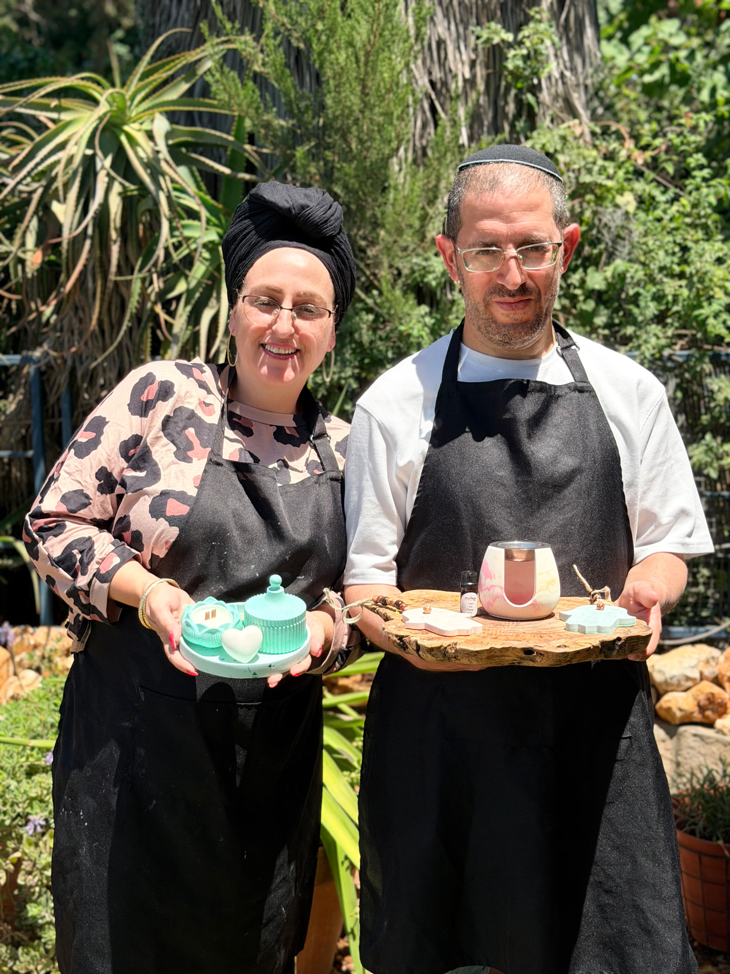 משתתפים מחזיקים מגשי כלים שהכינו – מבע טורקיז ומבער ורוד